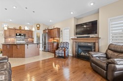 Living area with light wood-style floors, plenty of natural light, a high end fireplace, and recessed lighting - 