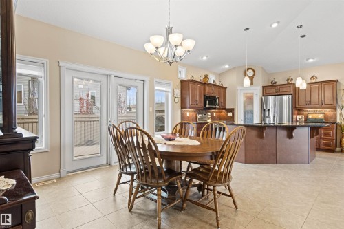 Dining area featuring lofted ceiling, light tile patterned floors, a chandelier, and recessed lighting - 50 Willow Wood Lane, Stony Plain, AB - Indoor Photo Showing Dining Room