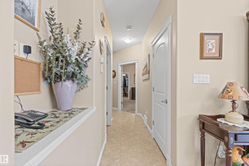 Corridor featuring light tile patterned floors and baseboards - 50 Willow Wood Lane, Stony Plain, AB - Indoor Photo Showing Other Room