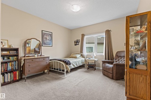 Bedroom featuring light carpet and a textured ceiling - 50 Willow Wood Lane, Stony Plain, AB - Indoor Photo Showing Bedroom