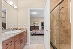 Bathroom with vanity, light tile patterned flooring, ensuite bathroom, a stall shower, and light colored carpet - 