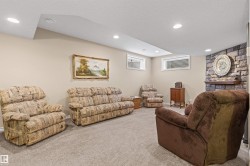 Living room with a textured ceiling, carpet floors, and recessed lighting - 