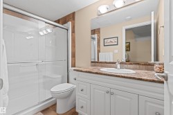Full bathroom with vanity, a shower stall, a textured ceiling, and tile patterned floors - 