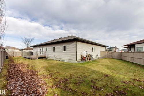 Rear view of property with a fenced backyard and a deck - 50 Willow Wood Lane, Stony Plain, AB - Outdoor With Backyard
