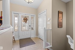 Entryway featuring light tile patterned flooring and a chandelier - 