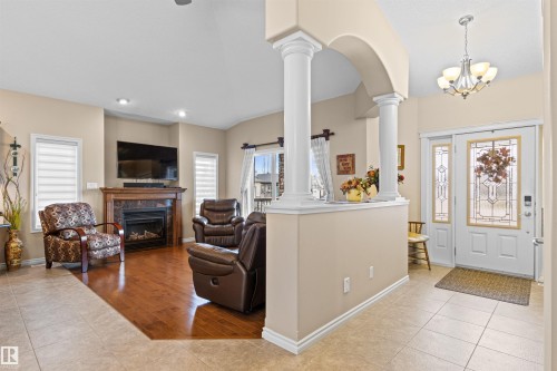 Entrance foyer featuring light tile patterned floors, plenty of natural light, a premium fireplace, and recessed lighting - 50 Willow Wood Lane, Stony Plain, AB - Indoor Photo Showing Living Room With Fireplace