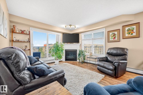 402 6070 Schonsee Way, Edmonton, AB - Indoor Photo Showing Living Room With Fireplace