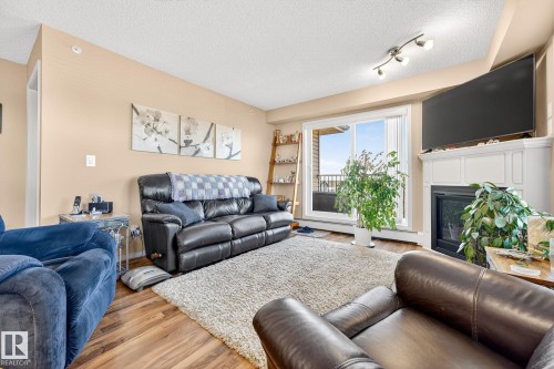 402 6070 Schonsee Way, Edmonton, AB - Indoor Photo Showing Living Room With Fireplace