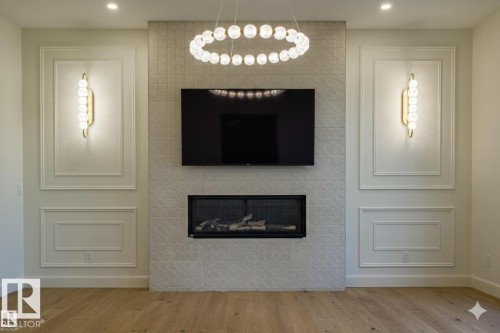 Detailed view of a large fireplace, wood finished floors, and recessed lighting - 12304 39 Avenue, Edmonton, AB 
