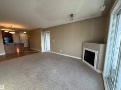Unfurnished living room with a textured ceiling, carpet floors, a fireplace, and plenty of natural light - 