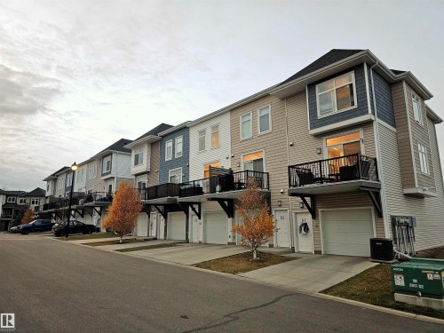 View of front facade featuring a balcony, a residential view, driveway, and a garage - 83 600 Bellerose Drive, St. Albert, AB - Outdoor