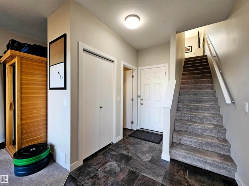 Stairway featuring a textured ceiling and stone finish floors - 83 600 Bellerose Drive, St. Albert, AB - Indoor Photo Showing Other Room
