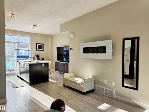Living area with a textured ceiling and light wood-style flooring - 83 600 Bellerose Drive, St. Albert, AB - Indoor
