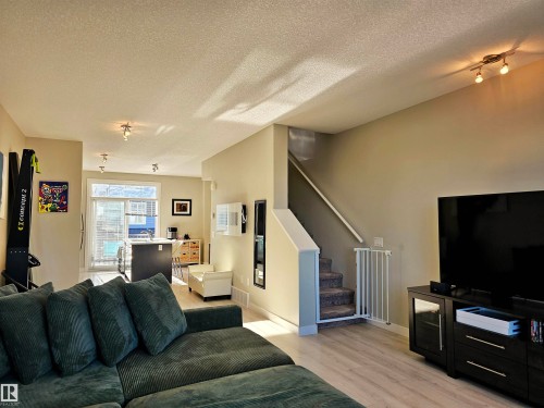 Living room featuring a textured ceiling, stairs, and light wood-type flooring - 83 600 Bellerose Drive, St. Albert, AB - Indoor Photo Showing Living Room