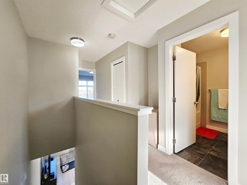 Hallway with dark carpet and an upstairs landing - 83 600 Bellerose Drive, St. Albert, AB - Indoor Photo Showing Other Room