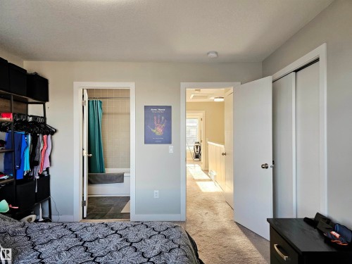 Bedroom featuring a closet, dark colored carpet, and connected bathroom - 83 600 Bellerose Drive, St. Albert, AB - Indoor Photo Showing Other Room