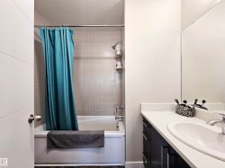 Bathroom with shower / bathtub combination with curtain, a textured ceiling, and vanity - 
