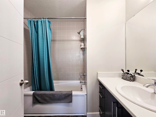 Bathroom with shower / bathtub combination with curtain, a textured ceiling, and vanity - 83 600 Bellerose Drive, St. Albert, AB - Indoor Photo Showing Bathroom