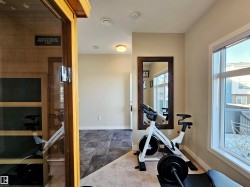 Workout area featuring a sauna / steam room and dark stone finish floors - 