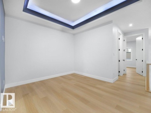 Unfurnished room featuring light wood-style flooring, a raised ceiling, and recessed lighting - 15419 20 Street, Edmonton, AB - Indoor Photo Showing Other Room