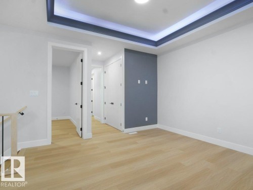 Spare room featuring light wood-style floors, a raised ceiling, and recessed lighting - 15419 20 Street, Edmonton, AB - Indoor Photo Showing Other Room