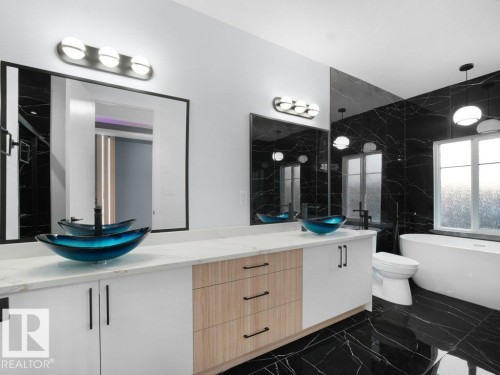 Bathroom with double vanity, dark marble finish floors, a soaking tub, tile walls, and walk in shower - 15419 20 Street, Edmonton, AB - Indoor Photo Showing Other Room