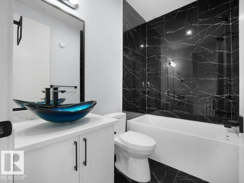 Bathroom with vanity and a combined bath / shower with marble appearance - 15419 20 Street, Edmonton, AB - Indoor Photo Showing Bathroom