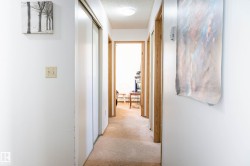 Corridor featuring light carpet and a textured ceiling - 