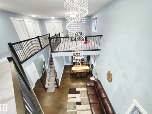 Staircase with a chandelier, wood finished floors, and a high ceiling - 1357 Watt Drive, Edmonton, AB - Indoor Photo Showing Other Room