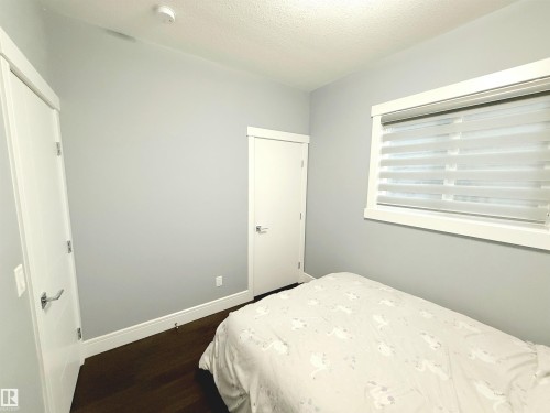 Bedroom with a textured ceiling and dark wood-style flooring - 1357 Watt Drive, Edmonton, AB - Indoor Photo Showing Bedroom
