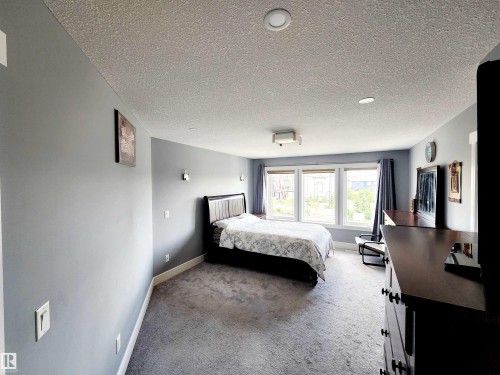 Bedroom with carpet and a textured ceiling - 1357 Watt Drive, Edmonton, AB - Indoor Photo Showing Bedroom