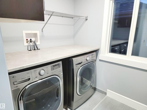 Laundry room with washer and clothes dryer and tile patterned flooring - 1357 Watt Drive, Edmonton, AB - Indoor Photo Showing Laundry Room