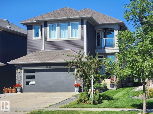 View of front facade featuring roof with shingles, an attached garage, driveway, and a front lawn - 1357 Watt Drive, Edmonton, AB - Outdoor With Facade