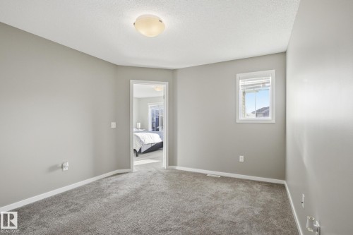 Carpeted spare room with a textured ceiling and baseboards - 893 Ebbers Crescent Nw, Edmonton, AB - Indoor Photo Showing Other Room