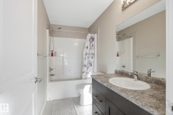 Full bathroom featuring vanity, shower / bathtub combination with curtain, and light tile patterned floors - 