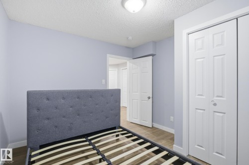 Bedroom featuring a textured ceiling, wood finished floors, and a closet - 893 Ebbers Crescent Nw, Edmonton, AB - Indoor Photo Showing Bedroom