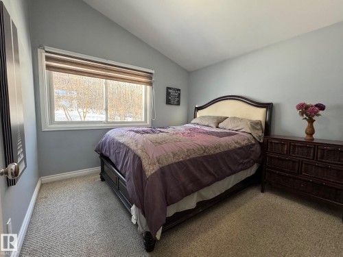 Bedroom featuring light carpet and vaulted ceiling - 4707 53 Street, Athabasca Town, AB - Indoor Photo Showing Bedroom