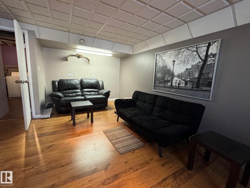 Living area featuring light wood-type flooring, washer / dryer, and a paneled ceiling - 4707 53 Street, Athabasca Town, AB - Indoor Photo Showing Other Room