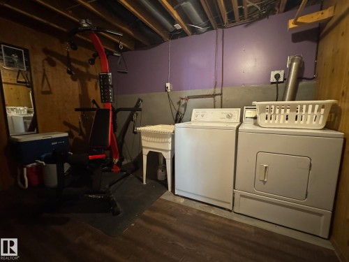 Laundry area with separate washer and dryer and dark wood-style flooring - 4707 53 Street, Athabasca Town, AB - Indoor Photo Showing Laundry Room