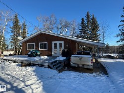 View of front facade with french doors, an attached carport, and a deck - 