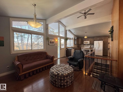 Living room with beamed ceiling, dark wood finished floors, a ceiling fan, and high vaulted ceiling - 4707 53 Street, Athabasca Town, AB - Indoor
