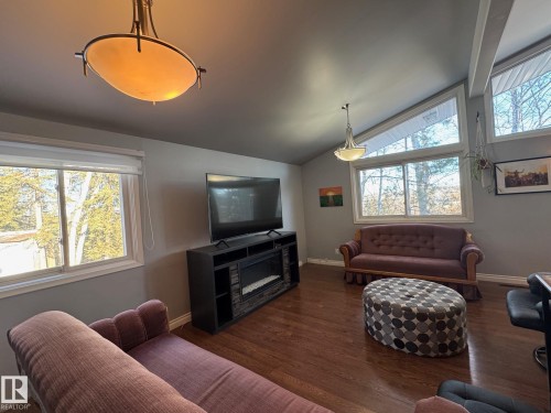 Living area with lofted ceiling and dark wood-style floors - 4707 53 Street, Athabasca Town, AB - Indoor Photo Showing Living Room