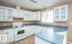 Kitchen with glass insert cabinets, white electric range, and white cabinets - 