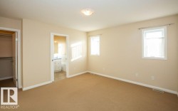 Unfurnished bedroom featuring a walk in closet, carpet, and ensuite bath - 