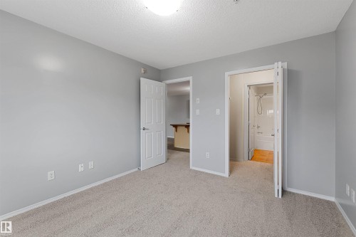 Unfurnished bedroom featuring light colored carpet and a textured ceiling - 111 5951 165 Avenue, Edmonton, AB - Indoor