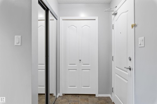 Doorway with stone finish floors and a textured ceiling - 111 5951 165 Avenue, Edmonton, AB - Indoor Photo Showing Other Room