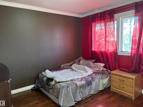 Bedroom featuring crown molding and dark wood-style flooring - 4813 52 Avenue, Elk Point, AB - Indoor Photo Showing Bedroom