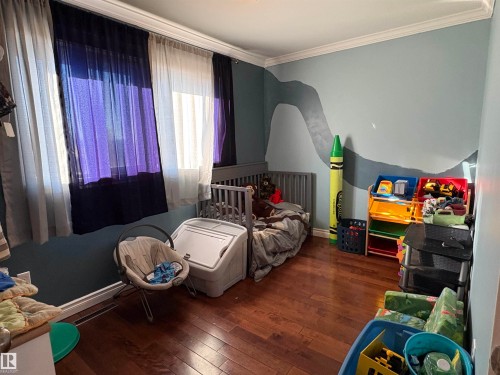 Bedroom featuring dark wood finished floors and ornamental molding - 4813 52 Avenue, Elk Point, AB - Indoor Photo Showing Bedroom