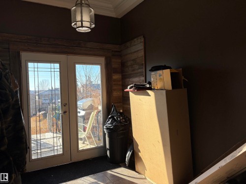 Entryway with french doors and crown molding, and heated floor. - 4813 52 Avenue, Elk Point, AB - Indoor Photo Showing Other Room