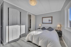 Bedroom featuring wood finished floors, crown molding, and ensuite bathroom - 